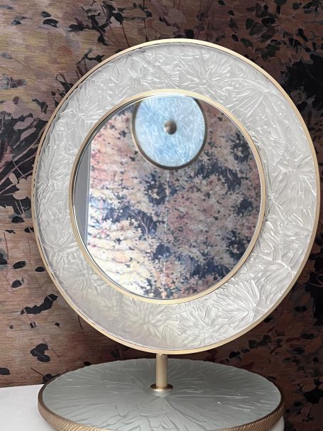 Miroir décoratif avec un cadre circulaire et une surface colorée.