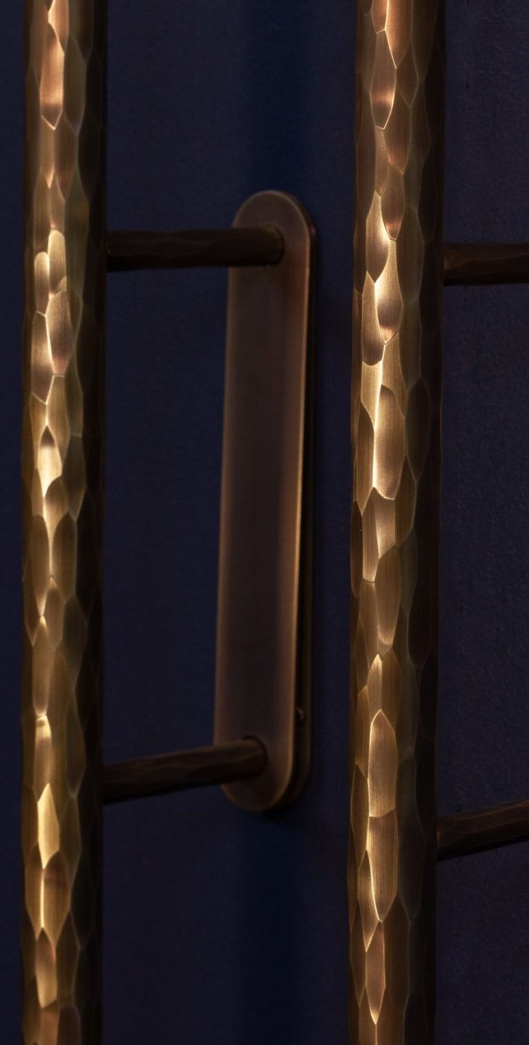 Lumières suspendues créant des reflets sur un plafond ondulé. 