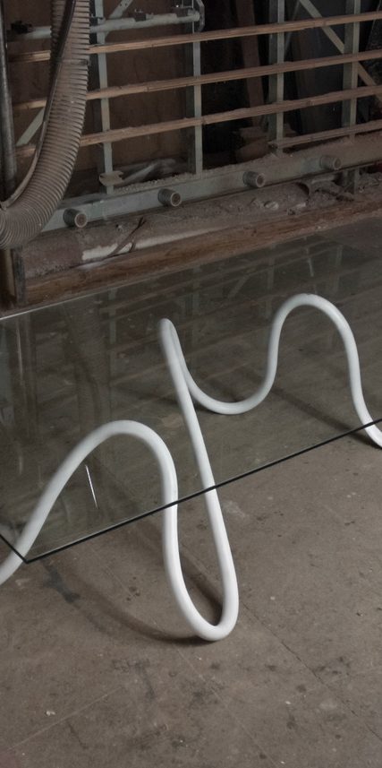 Suspension lumineuse en forme géométrique avec des lignes argentées et des lumières blanches.