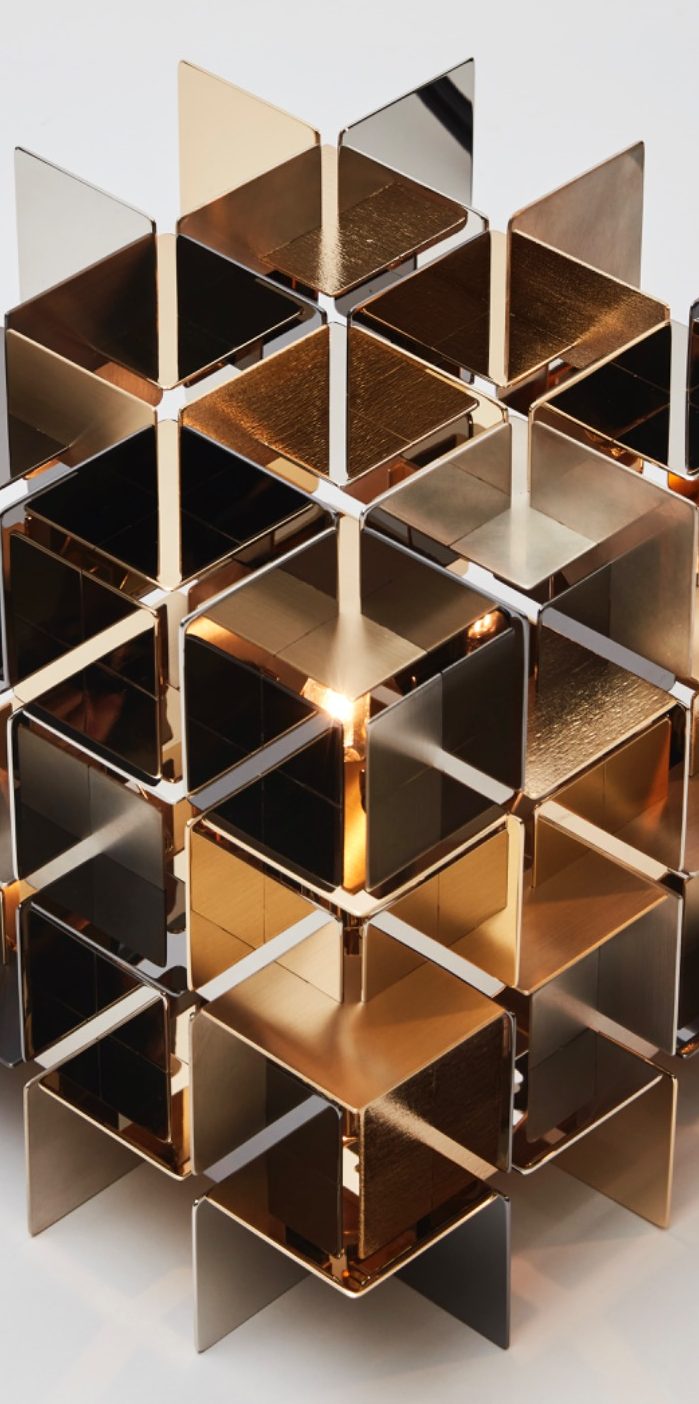 Structure géométrique en métal doré avec des motifs en cubes.