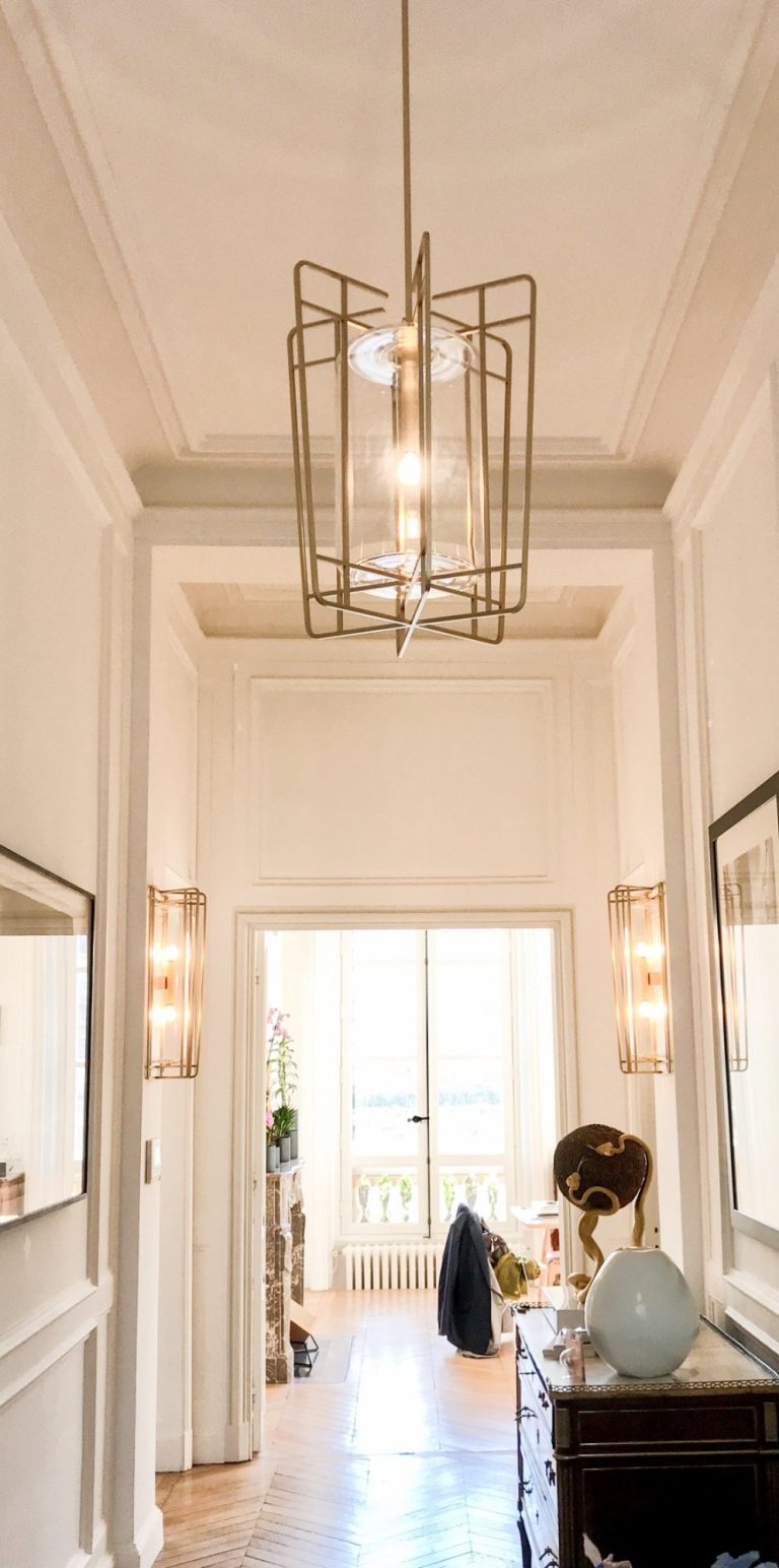 Suspension lumineuse en forme géométrique avec des lignes argentées et des lumières blanches.
