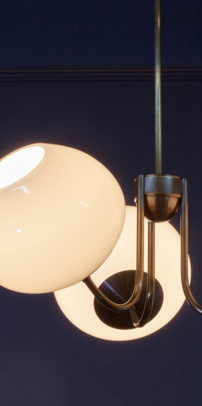 Suspension lumineuse en forme géométrique avec des lignes argentées et des lumières blanches.