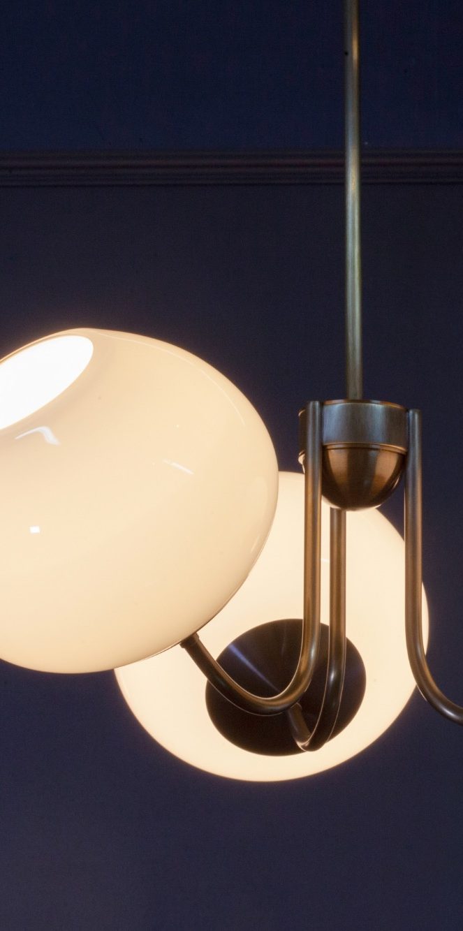 Suspension lumineuse en forme géométrique avec des lignes argentées et des lumières blanches.