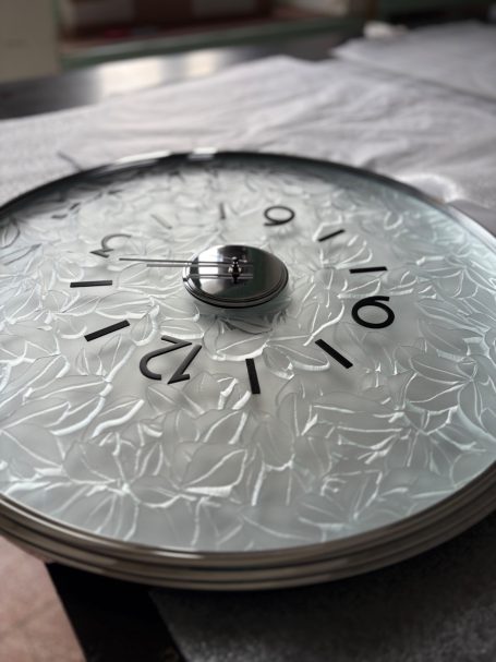 Un cadran de montre en gros plan, avec des chiffres et un design texturé.