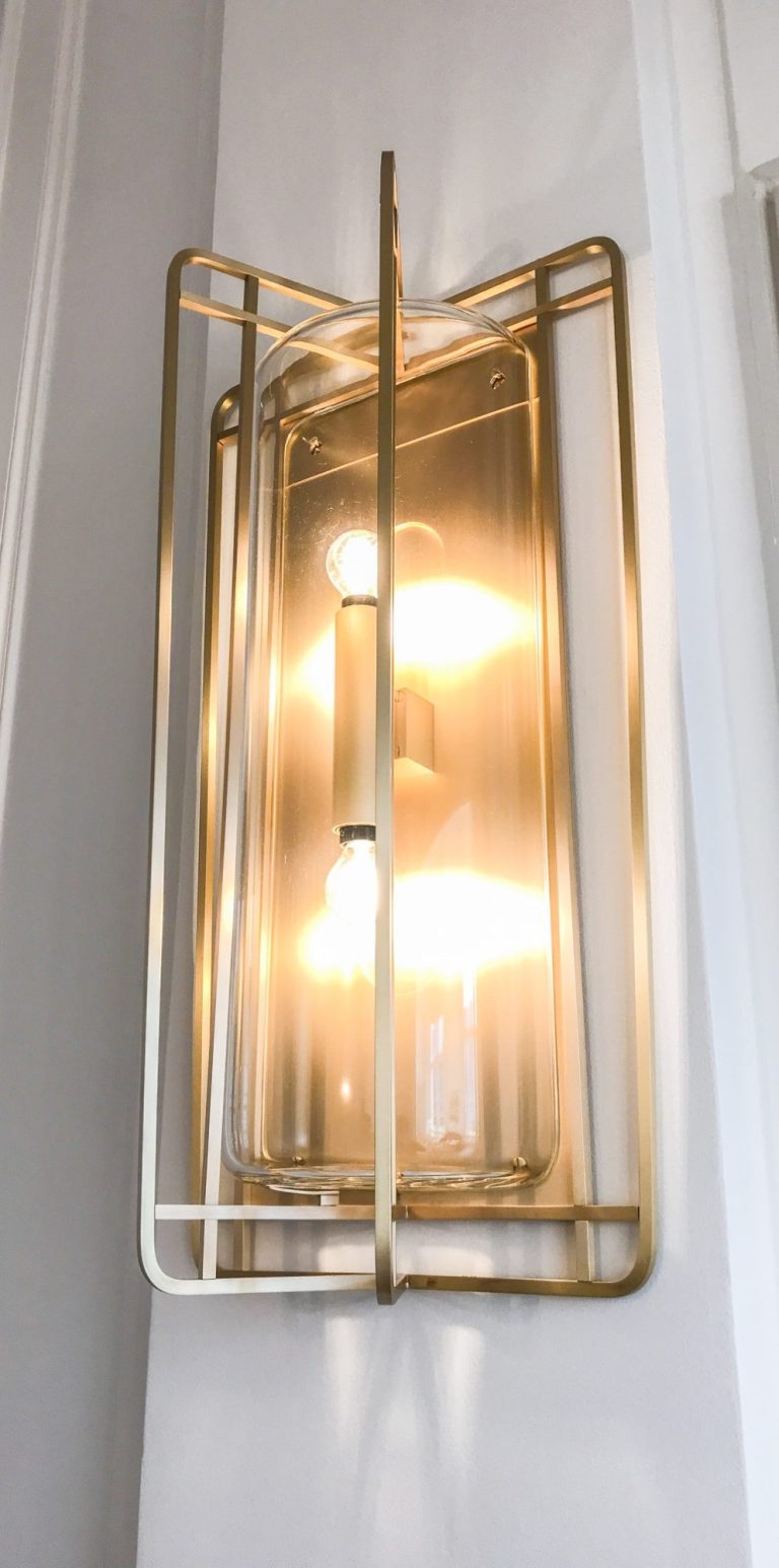 Suspension lumineuse en forme géométrique avec des lignes argentées et des lumières blanches.