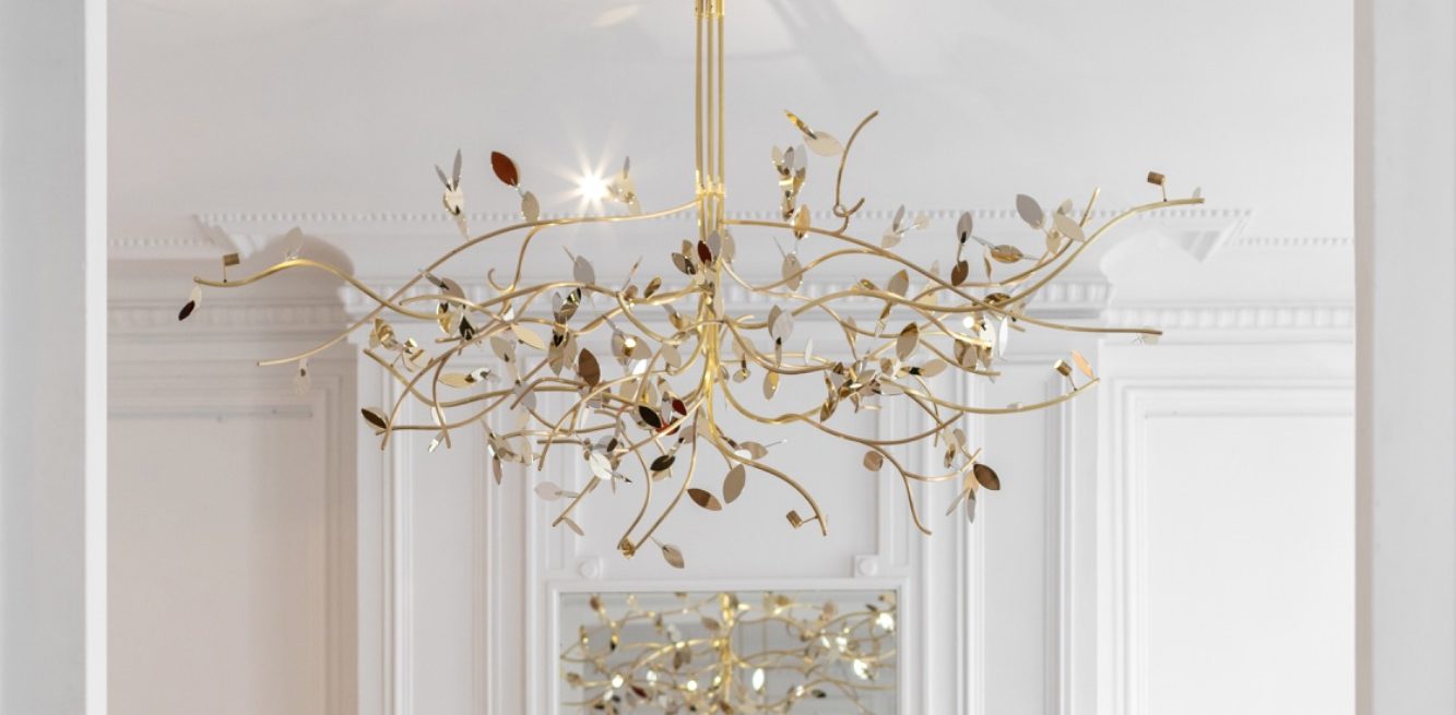 Lustre élégant en forme de branches avec des détails brillants et dorés.