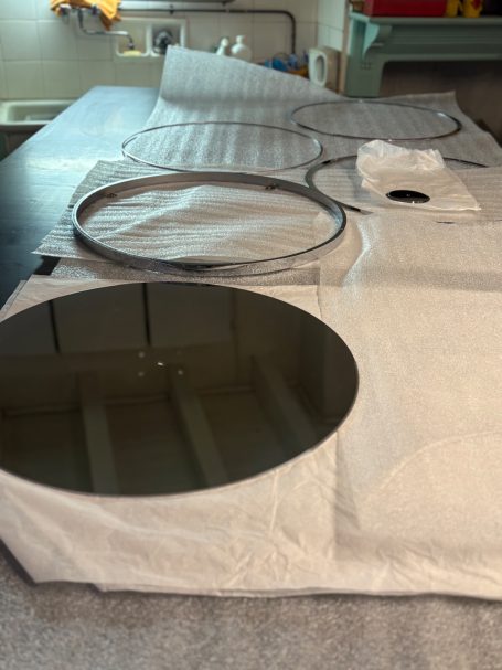 Trois grands disques de verre sur une surface de travail claire.