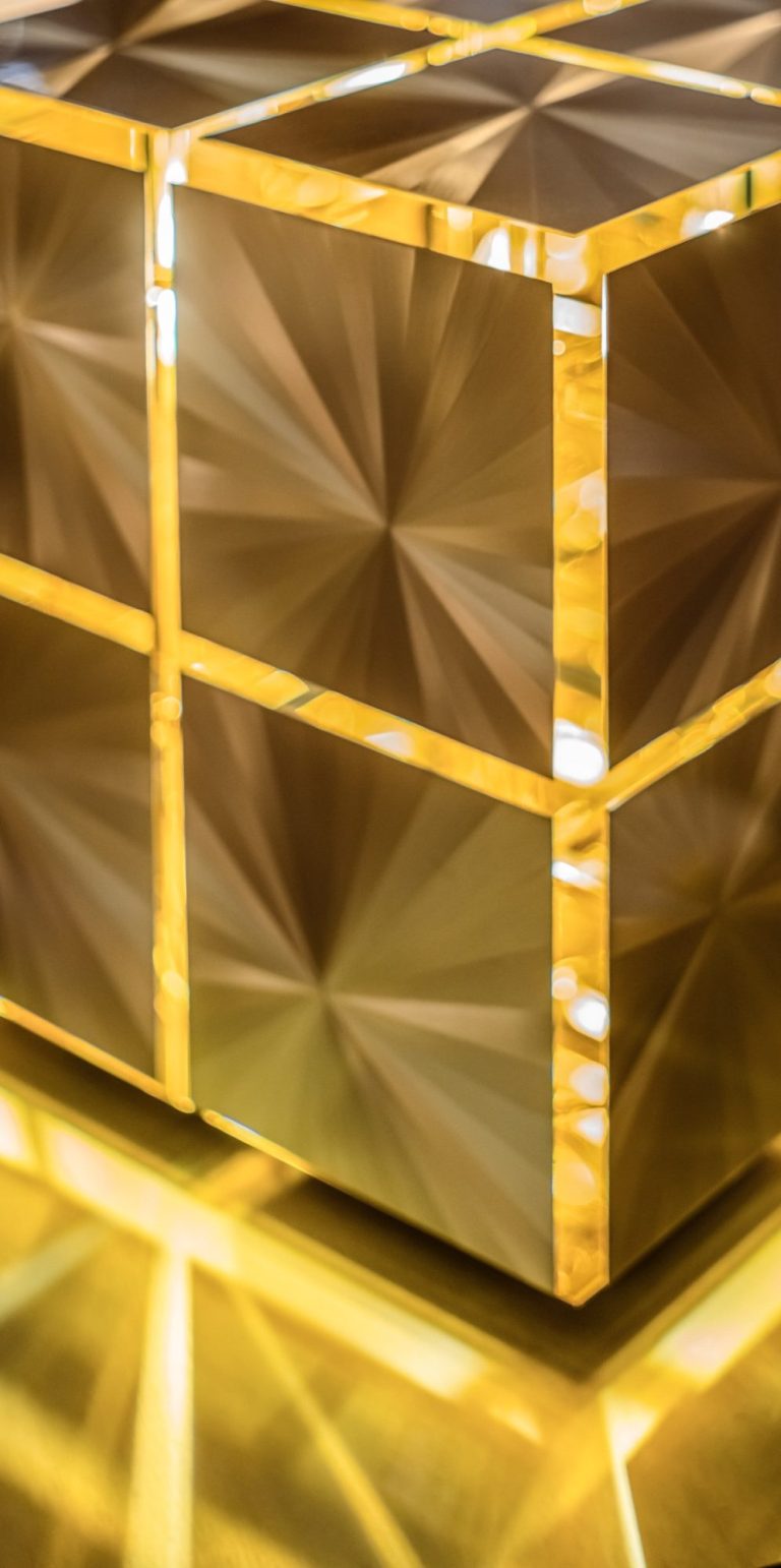 Lumières suspendues créant des reflets sur un plafond ondulé.